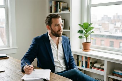 Jeune homme en blazer consulte documents immobiliers