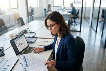 Professionnelle en entreprise consultant des documents de conformité ISO 27001 sur son bureau